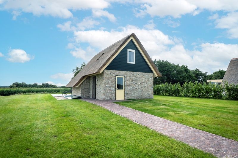 Landhaus-Ferienhaus in De Koog, Texel, mit einem schoenen Weg und gruener Umgebung.