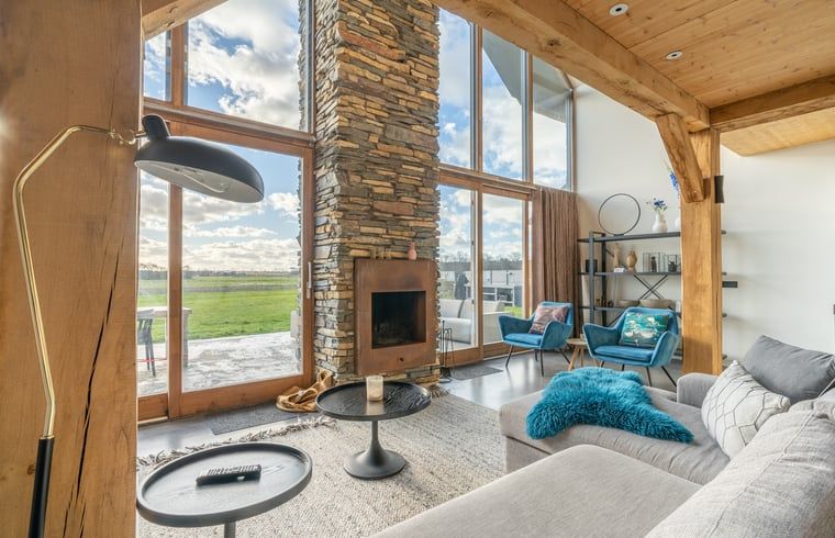 Cozy living room with fireplace in Holiday home in De Koog Texel, offers views of the nature of the Wadden Islands.