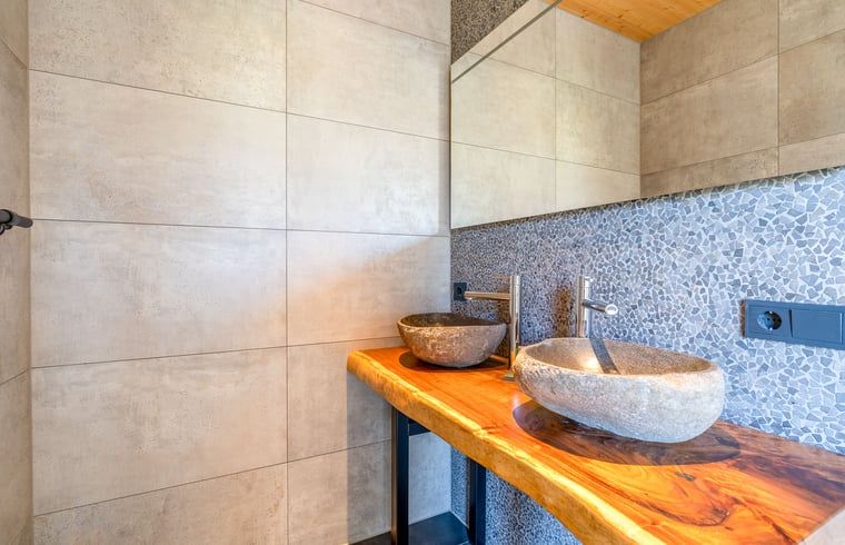 Elegant bathroom with natural stone sinks in Holiday home in De Koog Texel, ideal for relaxation on the Wadden Islands.
