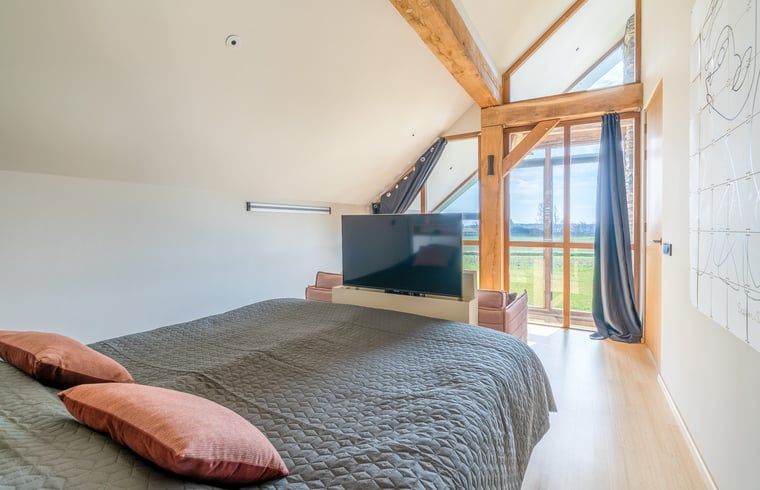 Bedroom with large window and view of nature in Holiday home in De Koog Texel, for a restful stay on the Wadden Islands.