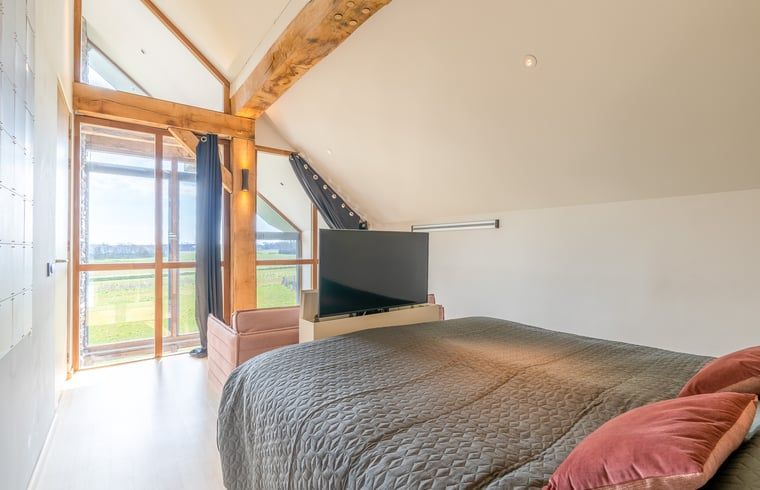 Bedroom with TV and nature view in Holiday home in De Koog Texel, offers relaxation on the Wadden Islands.