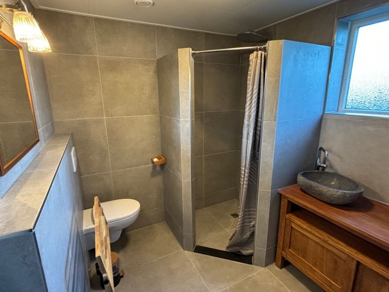Stylish bathroom in Stormvogel, vacation home De Koog, Texel with walk-in shower and sink.