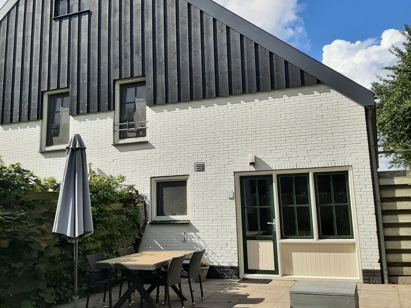 Sunny terrace with garden furniture at vacation home Stormvogel in De Koog, Texel.