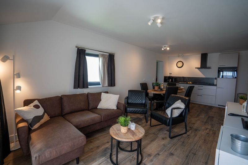 Spacious living room with open kitchen in Bungalow 2, De Koog, Texel, ideal for family gatherings.