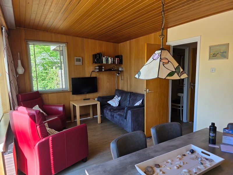 Gemuetliches Wohnzimmer im Bungalowpark De Nagtegaal - Bungalow 47, Texel, mit bequemen Sitzgelegenheiten.