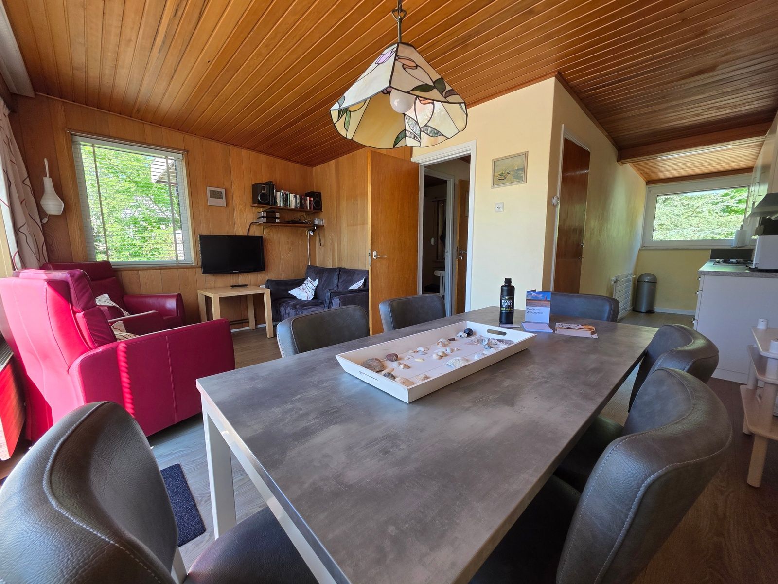 Offener Wohnbereich im Bungalowpark De Nagtegaal - Bungalow 47, Texel, mit Ess- und Sitzecke.