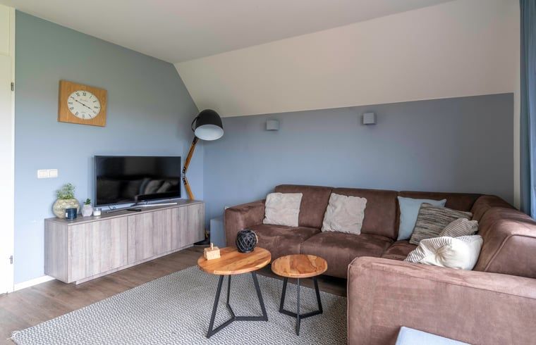 Gemuetliches Wohnzimmer im Ferienhaus in De Waal, Texel mit bequemem Sofa und moderner Einrichtung fuer einen entspannten Urlaub.