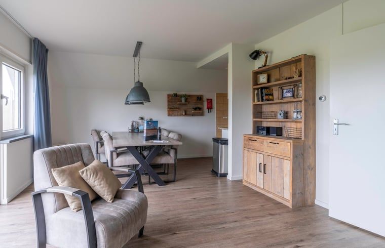 Esszimmer und Leseecke im Ferienhaus in De Waal, Texel, ideal fuer gemuetliche Mahlzeiten und entspannende Momente.
