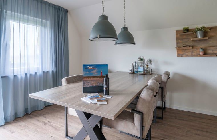 Stilvolles Esszimmer im Ferienhaus in De Waal, Texel mit modernem Tisch und stimmungsvoller Beleuchtung fuer gemuetliche Abendessen.