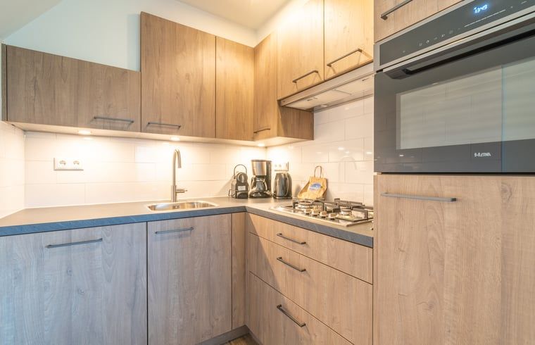 Moderne Kueche im Ferienhaus in De Waal, Texel, komplett ausgestattet fuer die Zubereitung leckerer Mahlzeiten.