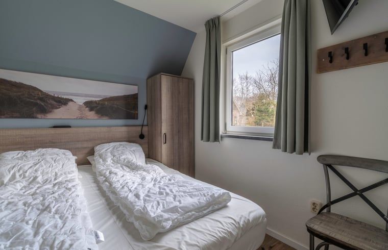 Komfortables Schlafzimmer im Ferienhaus in De Waal, Texel mit Doppelbett und Blick auf die ruhige Umgebung.