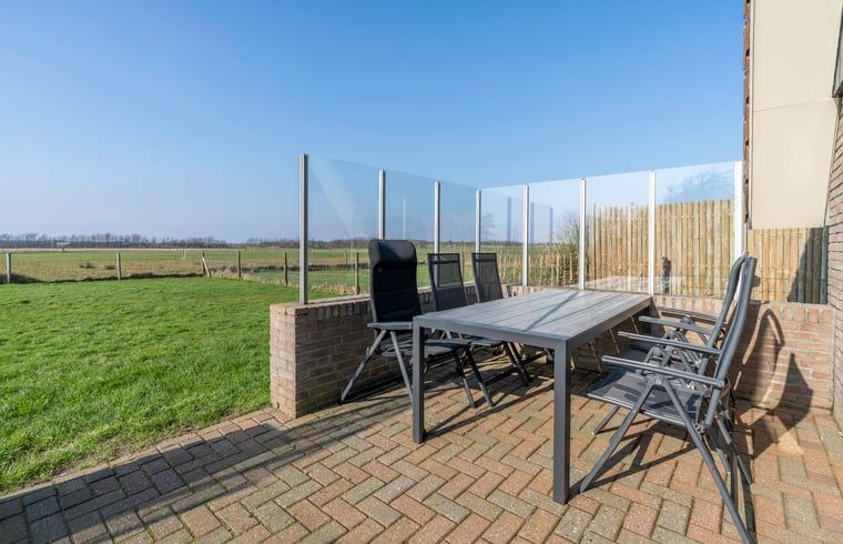 Geraeumige Terrasse mit Gartenmoebeln in einem Ferienhaus in De Waal, Texel, ideal um die Natur auf den Waddeninseln zu geniessen.