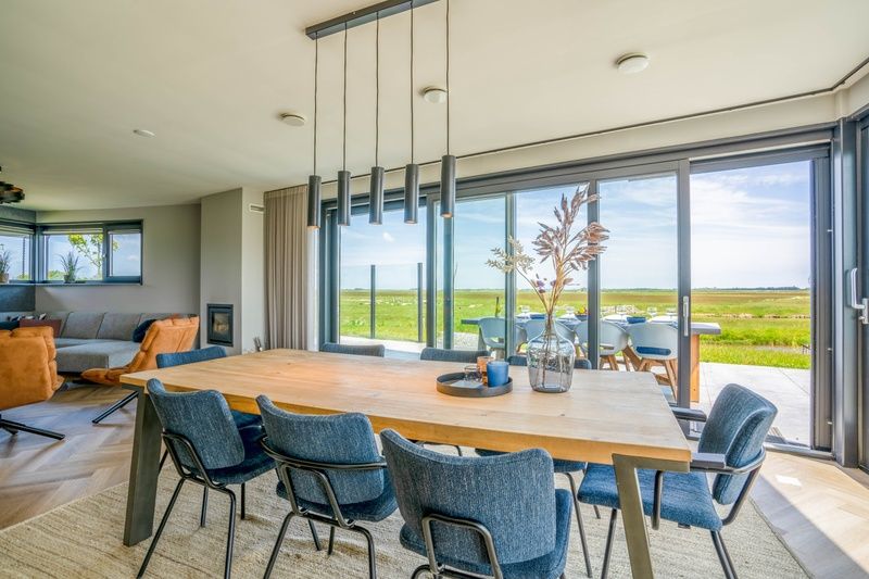 Gezellige eetruimte in Villa 24 Oosterkolk, De Waal, Texel met moderne meubels en uitzicht.