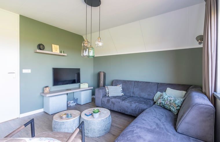 Stilvolle Sitzecke im Ferienhaus in De Waal, Texel mit moderner Einrichtung und Flachbildfernseher zur Entspannung.