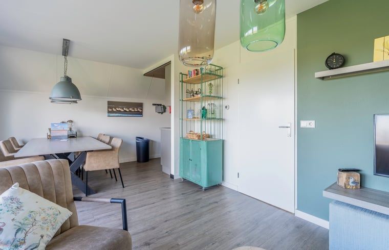 Essecke im Ferienhaus in De Waal, Texel, mit grossem Tisch und stilvollen Stuehlen, ideal fuer Familienabende.