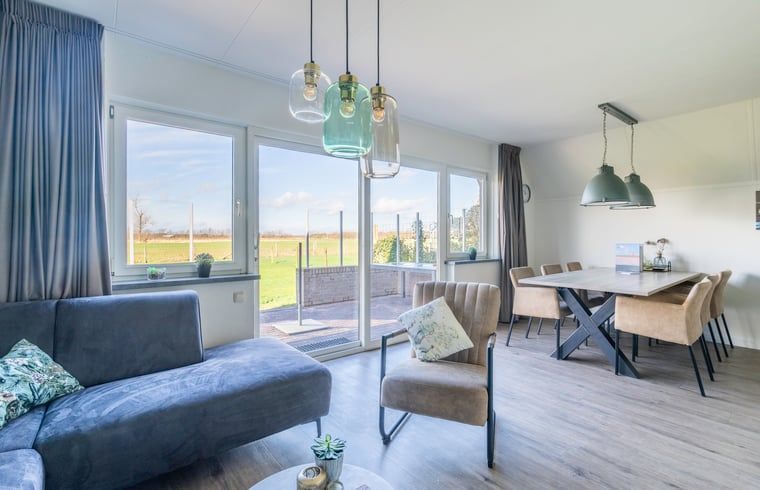 Helles Wohnzimmer im Ferienhaus in De Waal, Texel mit grossen Fenstern und schoener Aussicht auf die Natur von Texel.
