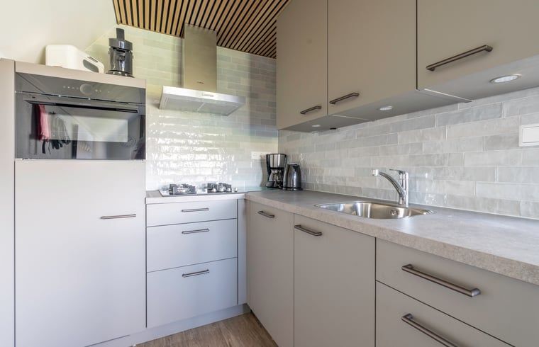 Voll ausgestattete Kueche im Ferienhaus in De Waal, Texel mit modernen Geraeten und stilvollen Oberflaechen.