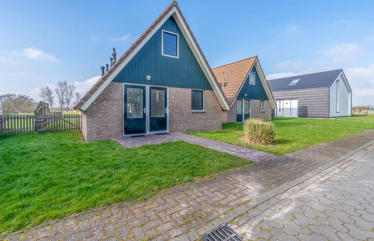 Vorderansicht des Ferienhauses in De Waal, Texel mit gepflegten Wegen und gruener Umgebung auf den Watteninseln.