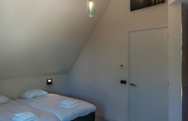 Badezimmer des Ferienhauses in Den Burg, Texel, mit moderner Dusche und Waschbecken.