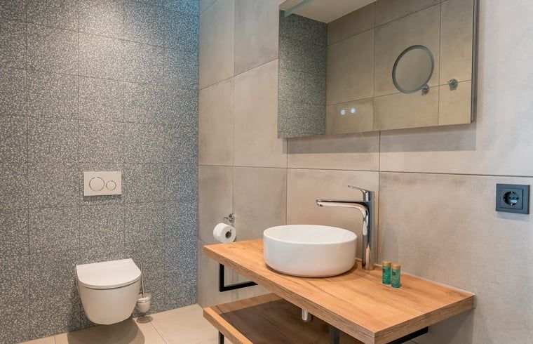 Kompakte Toilette mit Kacheln in einem Ferienhaus in Den Burg, Texel.