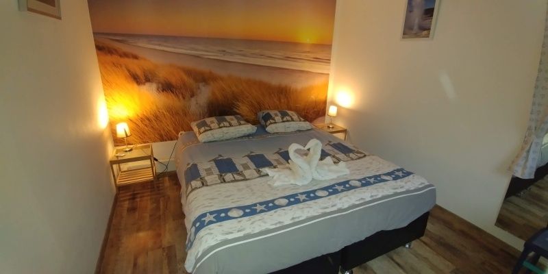 Comfortabele slaapkamer in Gastvrij vakantiehuis Den Burg, Texel, met strandthema voor een rustgevende nachtrust.