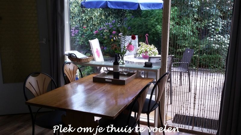 Eethoek met uitzicht op de tuin in Gastvrij vakantiehuis Den Burg, Texel, voor een huiselijk gevoel op de Waddeneilanden.