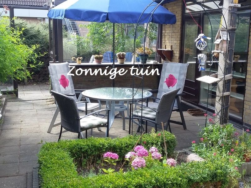 Zonnige tuin met zitplek bij Gastvrij vakantiehuis in Den Burg, Texel, ideaal voor buitenleven op de Waddeneilanden.