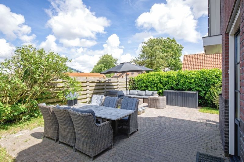 Geraeumige Terrasse der Villa Magnifique, Den Burg, Texel: bequeme Sitzgelegenheiten fuer Mahlzeiten im Freien.