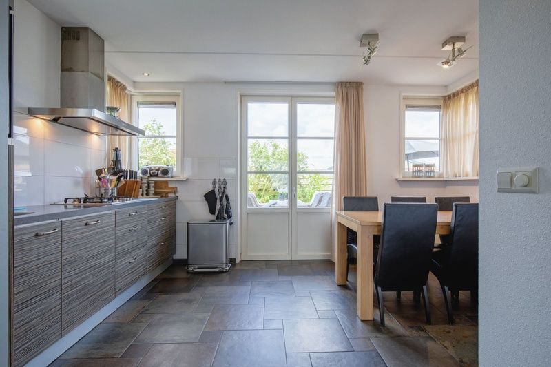 Kueche und Essbereich in der Villa Magnifique, Den Burg, Texel: geraeumige Einrichtung mit Zugang zur Terrasse.