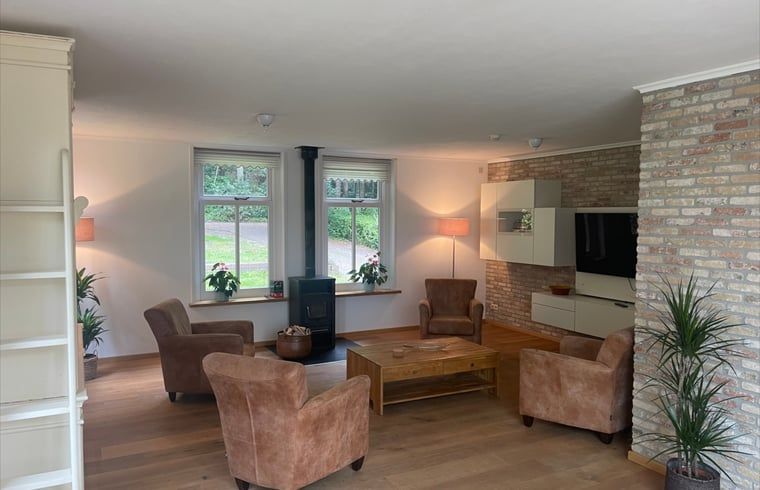Cozy living room of Cottage in Den Burg, Texel with comfortable seating area and large windows.