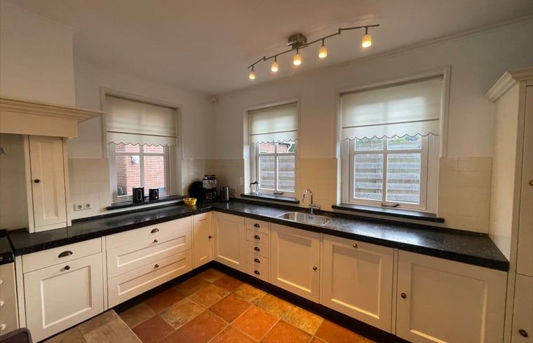 Stylish kitchen in cottage in Den Burg, Texel with modern appliances and lots of light.