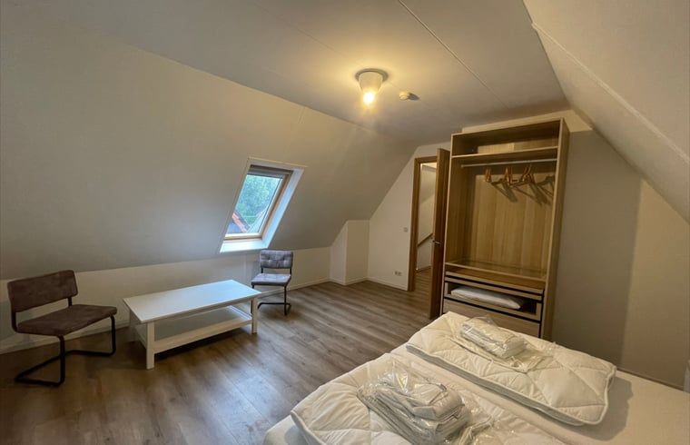Spacious bedroom on the attic floor of Cottage in Den Burg, Texel, with lots of natural light.
