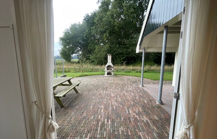 Cozy terrace with barbecue at cottage in Den Burg, Texel, for outdoor meals and relaxation.