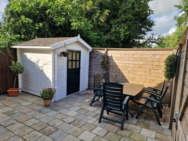 Sonnige Terrasse mit Gartenmoebeln im Ferienhaus Kogerstraat, Den Burg, Texel. Geniessen Sie die Natur auf den Watteninseln.