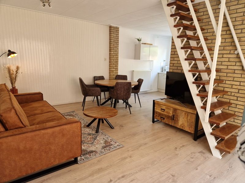 Offenes Wohnzimmer mit Treppe im Ferienhaus Kogerstraat, Den Burg, Texel. Raum fuer Entspannung und Gemuetlichkeit auf Texel.