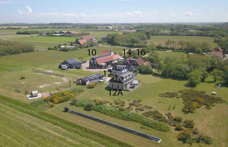 Luftaufnahme von Cottage in Den Burg, Texel, Ferienhaus auf den Watteninseln in gruener Umgebung.
