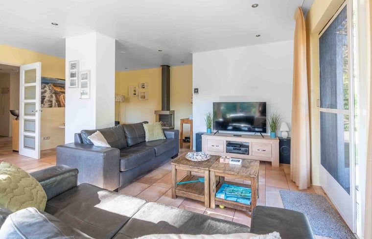 Geraeumige Sitzecke in einem Ferienhaus in Den Burg, Texel, mit moderner Einrichtung und viel Licht.