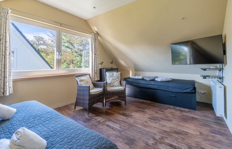 Geraeumiges Schlafzimmer in Haus in Den Burg, Ferienhaus auf Texel, mit Sitzecke und TV.