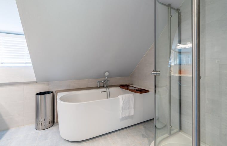 Luxurioeses Badezimmer mit Badewanne und Dusche in Cottage in Den Burg, Texel, Ferienhaus auf den Watteninseln.