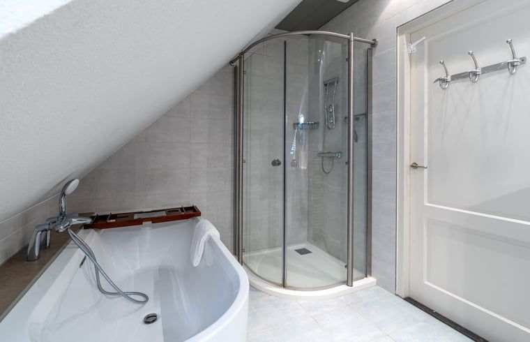 Modernes Badezimmer mit Badewanne und Dusche in Haus in Den Burg, Ferienhaus auf Texel.