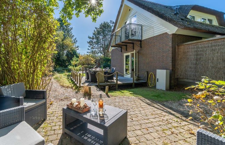 Rustikaler Garten des Ferienhauses in Den Burg, Texel mit Sitzgelegenheit und Grill, ideal zum Entspannen.