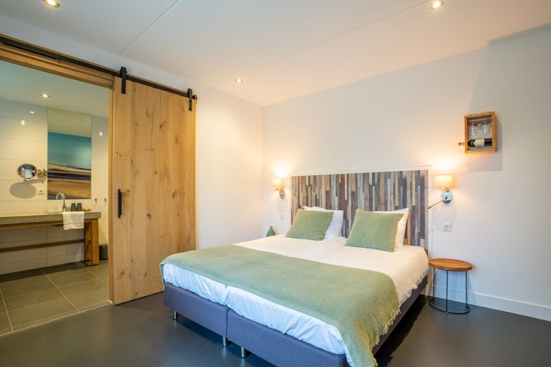 Komfortables Schlafzimmer mit eigenem Bad in der Gruppenunterkunft Nieuw Leven 36p, Den Burg, Texel.