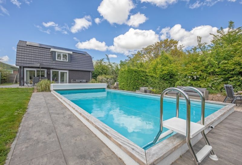 Sunny terrace at Villa 3C in Den Burg, Texel overlooking the pool, perfect for a relaxing vacation.