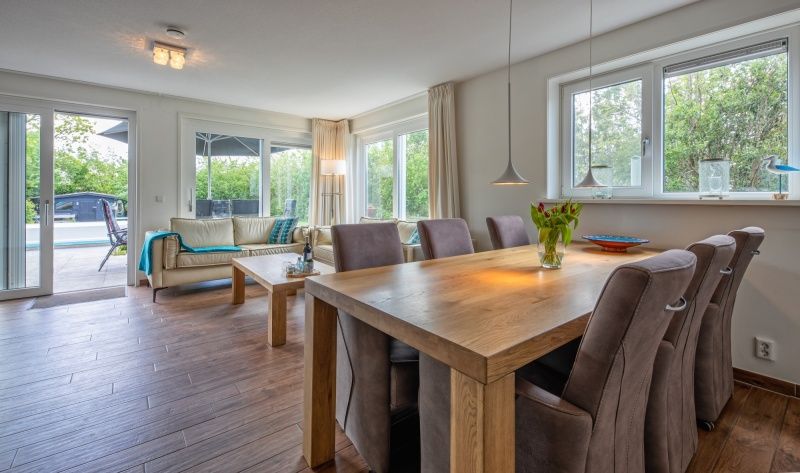 Cozy dining room in Villa 3C, Den Burg, Texel, overlooking the green surroundings, ideal vacation home.