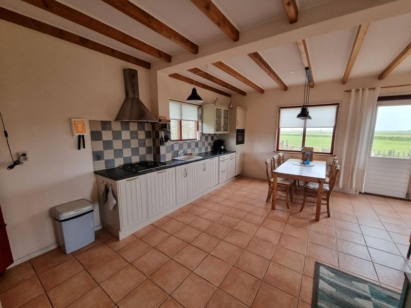 Geraeumige Kueche im Ferienhaus Duinzicht Den Burg Texel mit Landhausstil und Blick auf die Natur.
