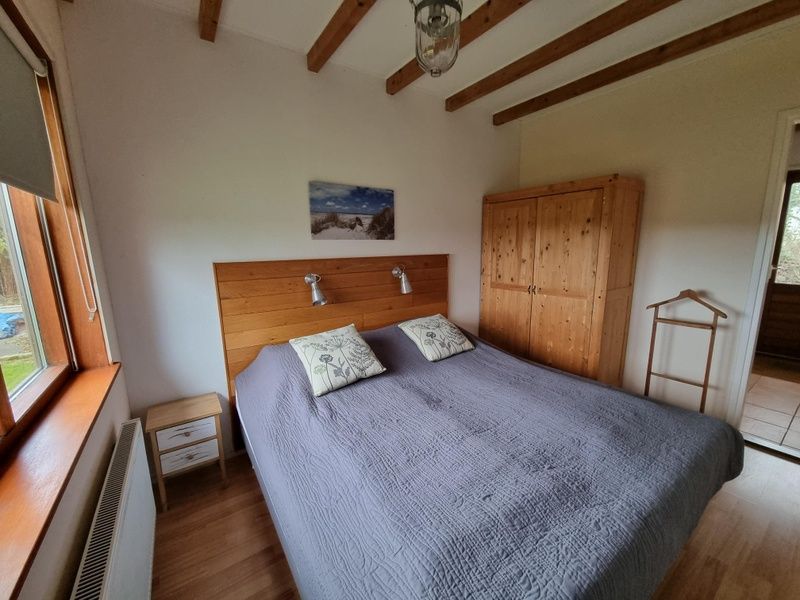 Gemuetliches Schlafzimmer im Ferienhaus Duinzicht Den Burg Texel mit Holzdetails und laendlichem Charme.