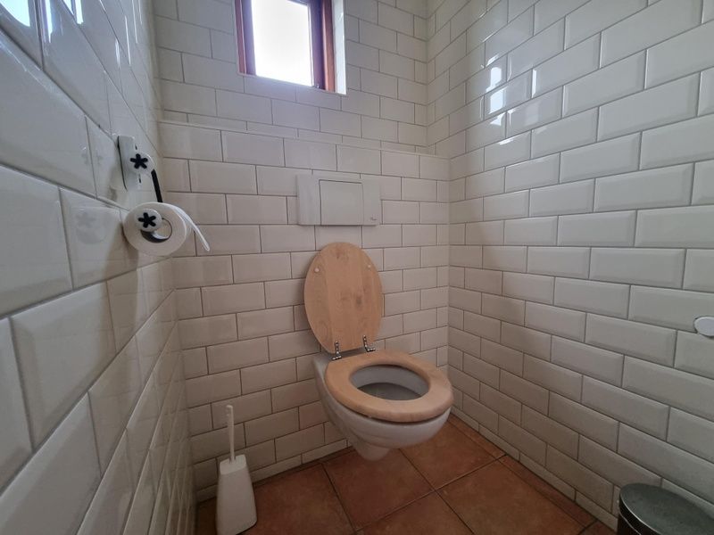Gepflegte Toilette im Ferienhaus Duinzicht Den Burg Texel mit weiss gefliesten Waenden.