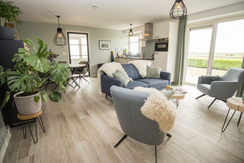 Ruime woonkamer van Onder de Wol vakantiehuis Texel met uitzicht op de natuur.