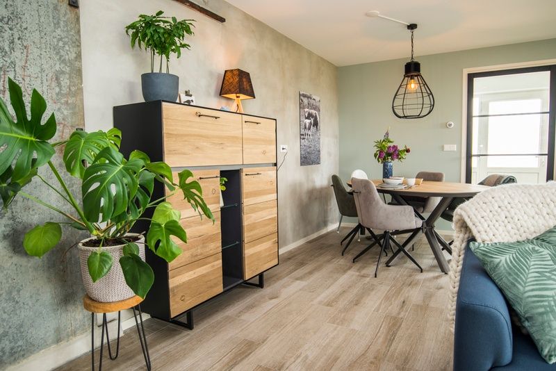 Moderne eetkamer in Onder de Wol Den Burg, Texel met sfeervolle decoratie en planten.