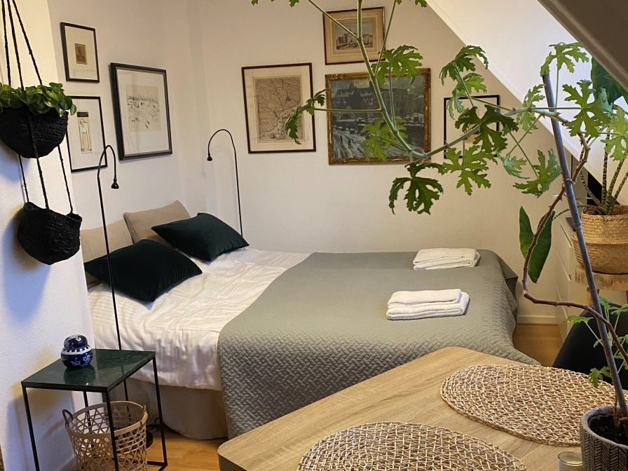 Gemuetliches Schlafzimmer im Doppelstudio 1 in Den Hoorn, Texel, mit Kunst an der Wand und gruenen Akzenten.